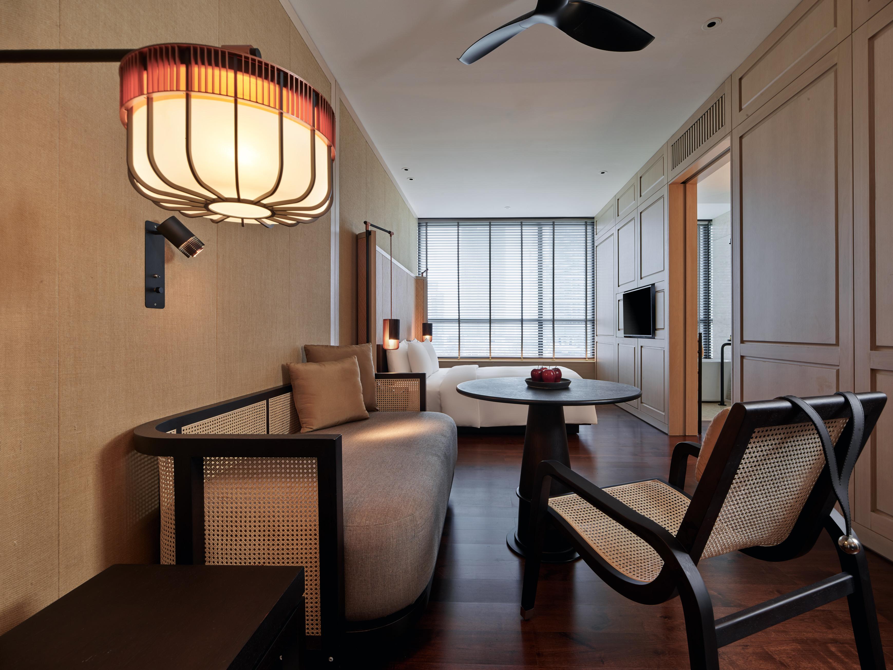 The Ruma Hotel And Residences Kuala Lumpur Exterior foto The photo shows a stylish and modern interior of a hotel room or a living space. The decor features warm tones and natural materials, with a wall finished in light wood or beige. 

In the foreground, there is a round table with a small decorative ite